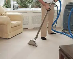 Carpet cleaning professional removing dirt and stains with a hot-water extraction tool in a home, Saint Louis, MO.